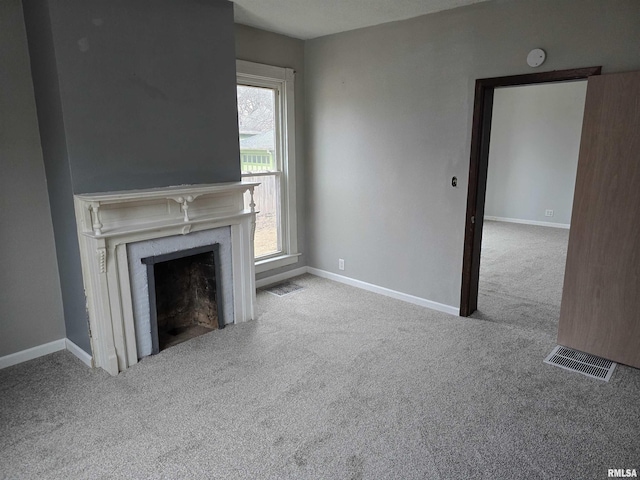 unfurnished living room with light carpet, a fireplace, visible vents, and baseboards