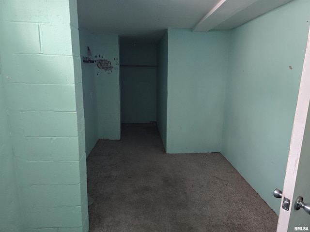 hallway with carpet and concrete block wall