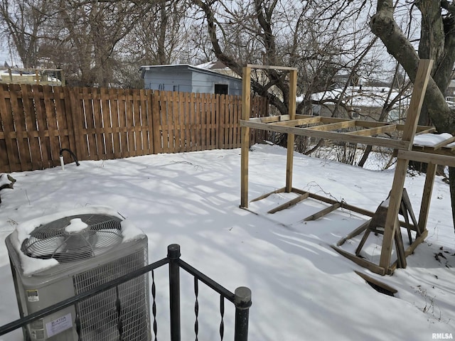 yard layered in snow with central AC and fence