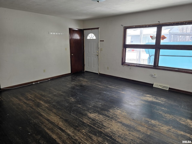 entrance foyer with dark wood-style floors, visible vents, and baseboards