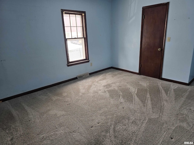 spare room featuring carpet floors, baseboards, and visible vents