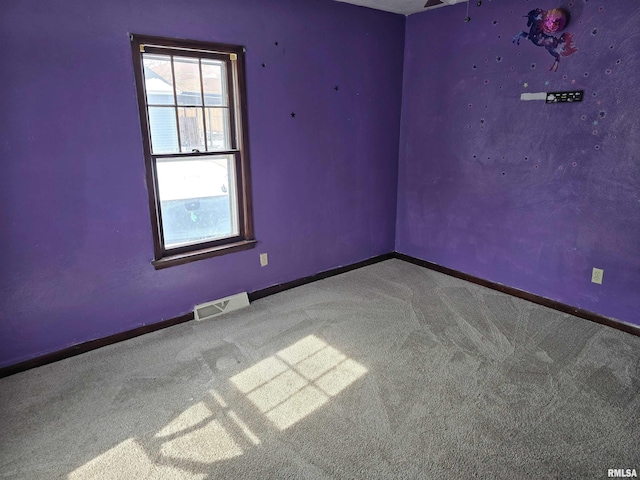 empty room featuring carpet, visible vents, and baseboards