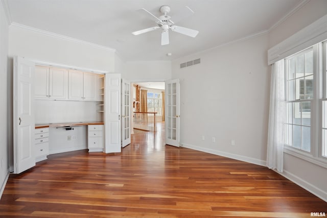 unfurnished bedroom with ornamental molding, french doors, dark wood-type flooring, and built in desk