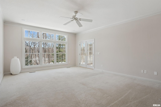 unfurnished room with baseboards, light colored carpet, ceiling fan, crown molding, and french doors