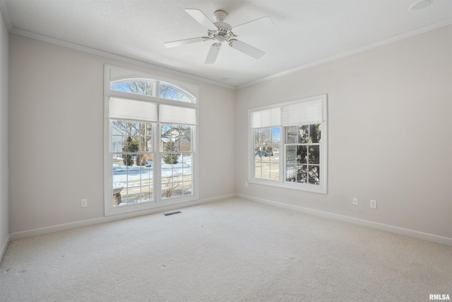 unfurnished room featuring light carpet, plenty of natural light, visible vents, and crown molding