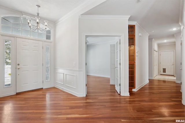 entrance foyer featuring ornamental molding and wood finished floors