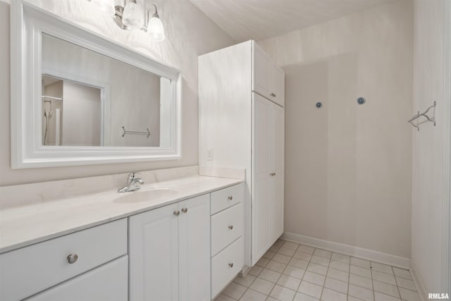 bathroom with tile patterned flooring, baseboards, and vanity