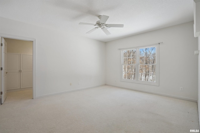 unfurnished bedroom with a ceiling fan, baseboards, a textured ceiling, and light colored carpet