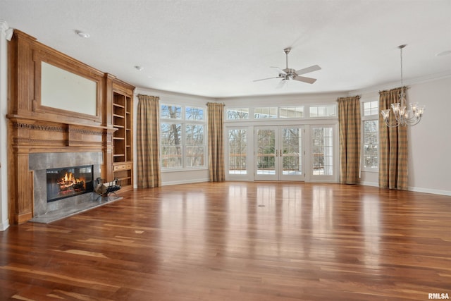 unfurnished living room featuring baseboards, a high end fireplace, ornamental molding, dark wood-style flooring, and ceiling fan with notable chandelier