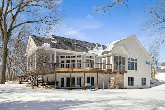 snow covered house featuring a wooden deck