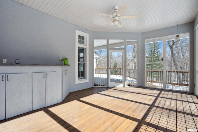 unfurnished sunroom with ceiling fan