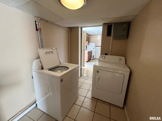 laundry area with light tile patterned floors, washing machine and dryer, electric panel, and laundry area