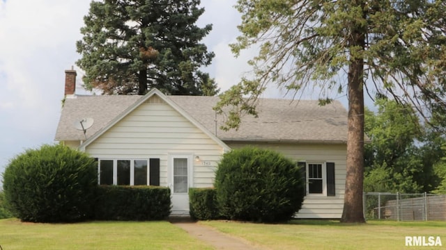 back of property featuring a chimney, fence, a lawn, and roof with shingles