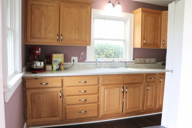 kitchen with brown cabinets, light countertops, and a sink