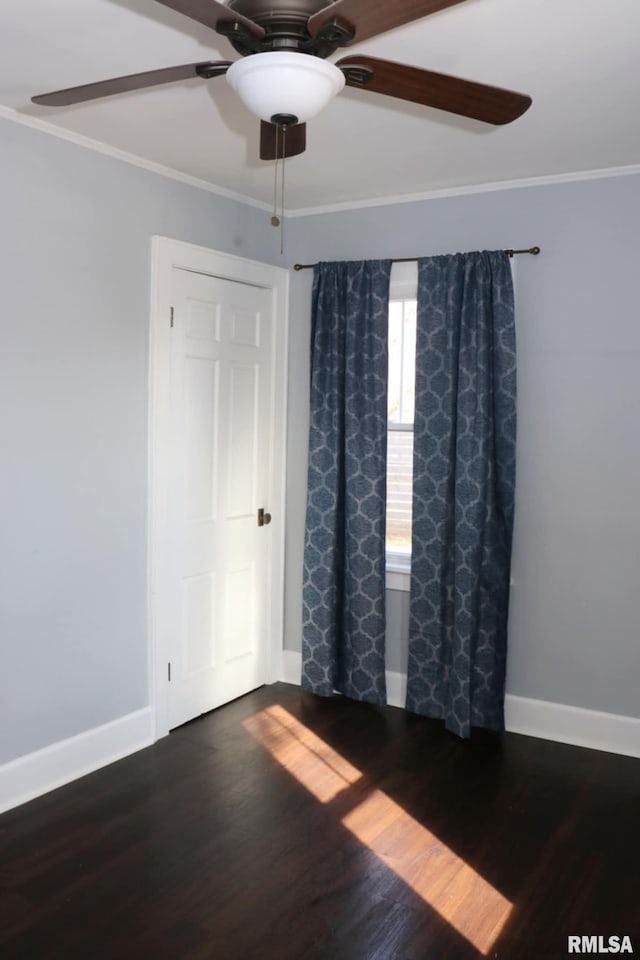 unfurnished room featuring ornamental molding, a ceiling fan, baseboards, and dark wood-style floors