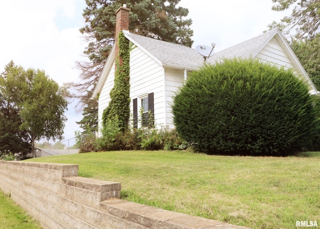 view of home's exterior with a lawn and a chimney