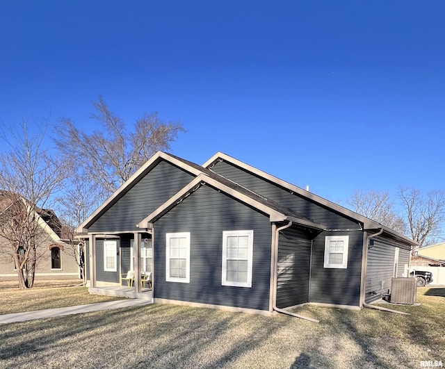 view of front of home with central AC unit and a front yard