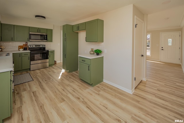 kitchen featuring stainless steel appliances, light countertops, and green cabinets