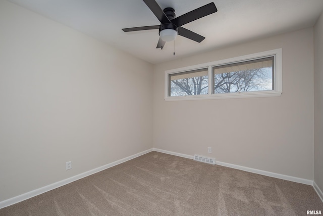 empty room featuring a ceiling fan, carpet flooring, visible vents, and baseboards