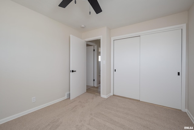 unfurnished bedroom featuring baseboards, a closet, and light colored carpet