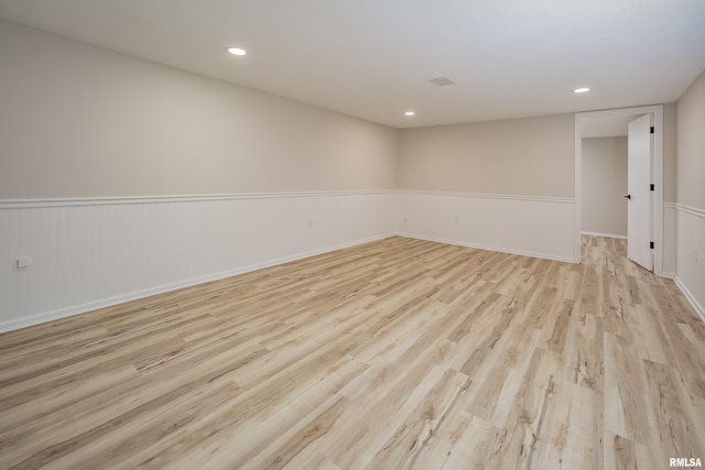 empty room featuring recessed lighting, baseboards, and light wood finished floors