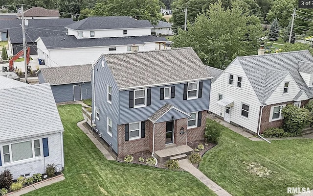 exterior space featuring brick siding, a front lawn, and a shingled roof