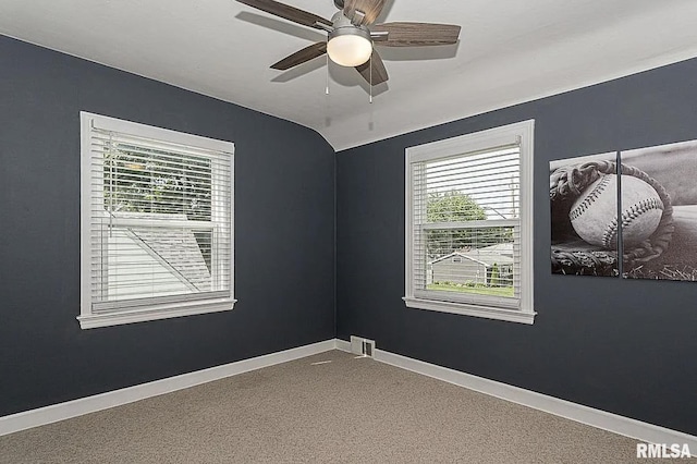 carpeted empty room with lofted ceiling, a ceiling fan, and baseboards