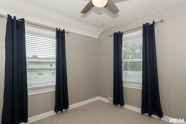 spare room with ceiling fan, vaulted ceiling, and baseboards