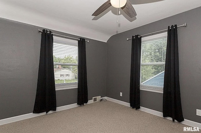 unfurnished room featuring a ceiling fan, lofted ceiling, visible vents, and baseboards