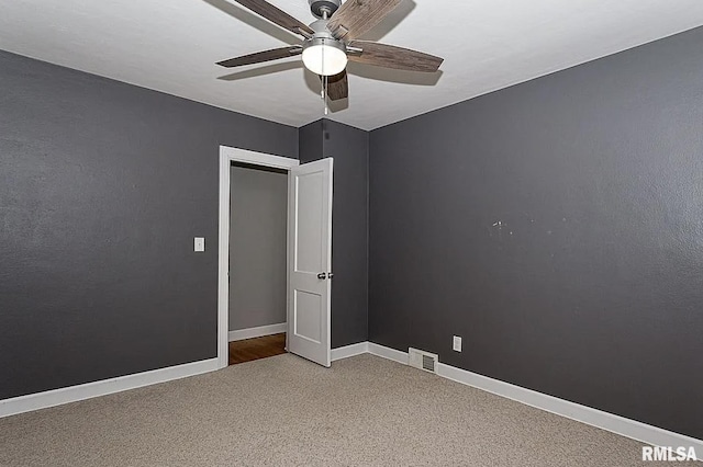 spare room featuring carpet, visible vents, ceiling fan, and baseboards