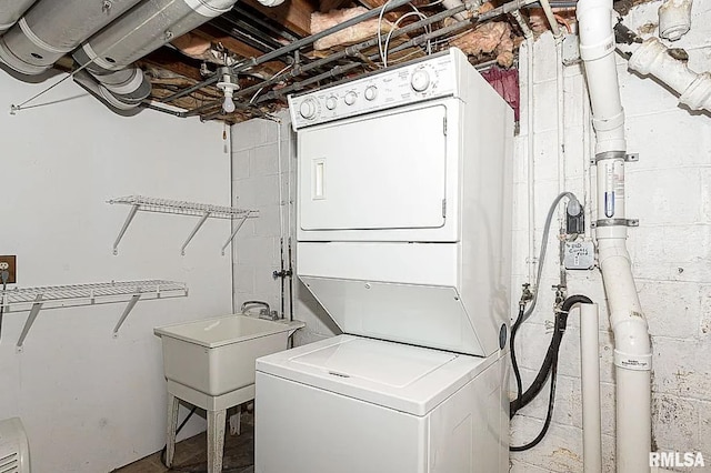 washroom featuring stacked washer and dryer and laundry area