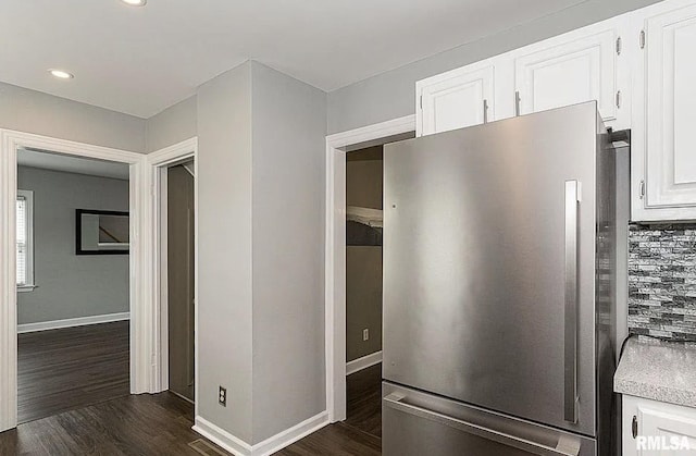 kitchen with light countertops, dark wood finished floors, freestanding refrigerator, and white cabinetry