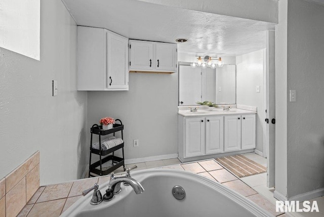 full bath featuring a textured ceiling, a garden tub, double vanity, and a sink