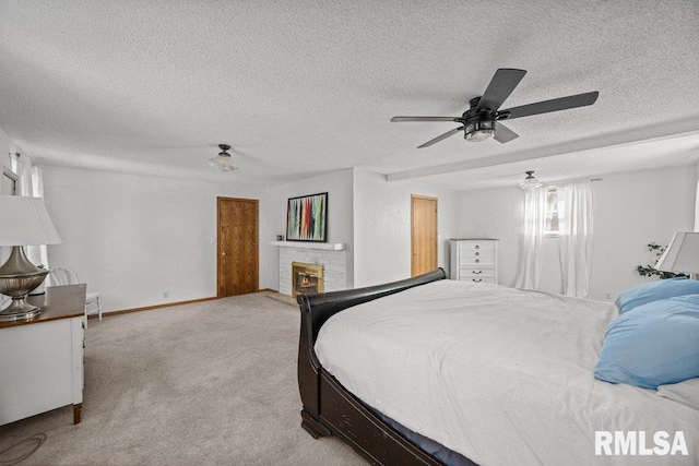 bedroom featuring light carpet, a textured ceiling, baseboards, a brick fireplace, and ceiling fan