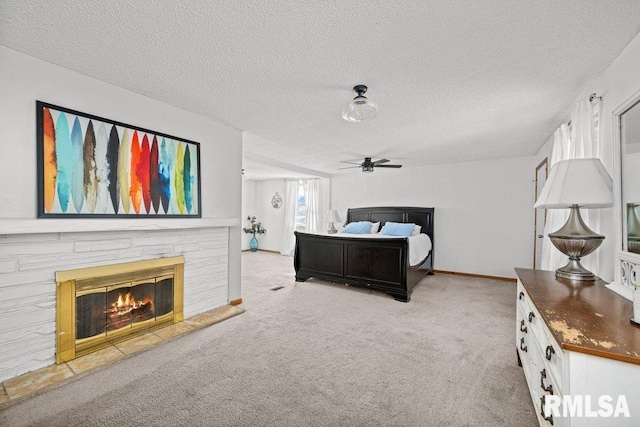 bedroom with baseboards, light colored carpet, a fireplace, and a textured ceiling