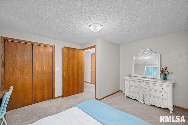 bedroom featuring a textured ceiling, baseboards, a closet, and light carpet