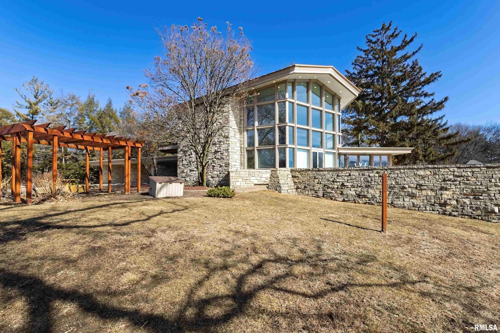 rear view of property with a yard and a pergola