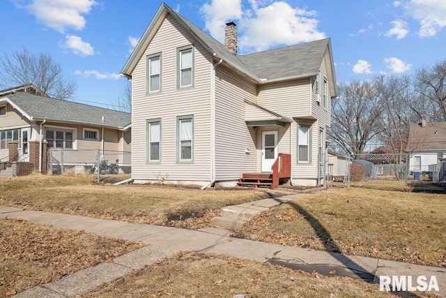 exterior space featuring fence, a chimney, and a front lawn