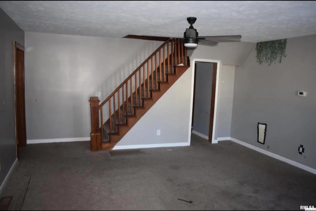 334 E S St, Mendon, IL 62351 - unfurnished living room with a ceiling fan, dark carpet, baseboards, and stairs