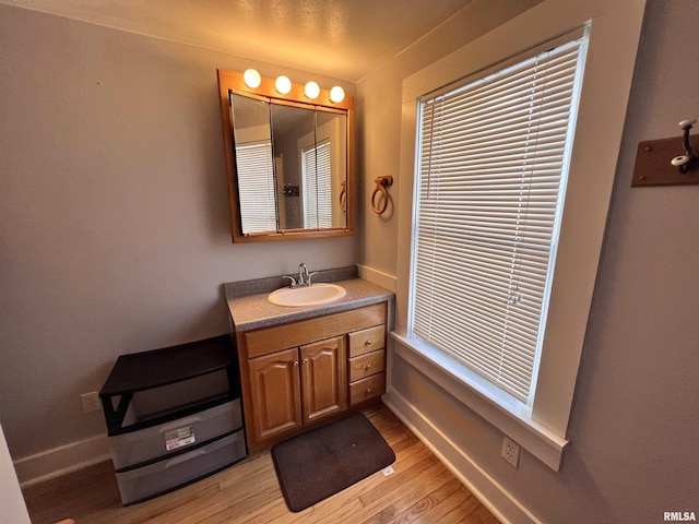 bathroom featuring vanity, baseboards, and wood finished floors