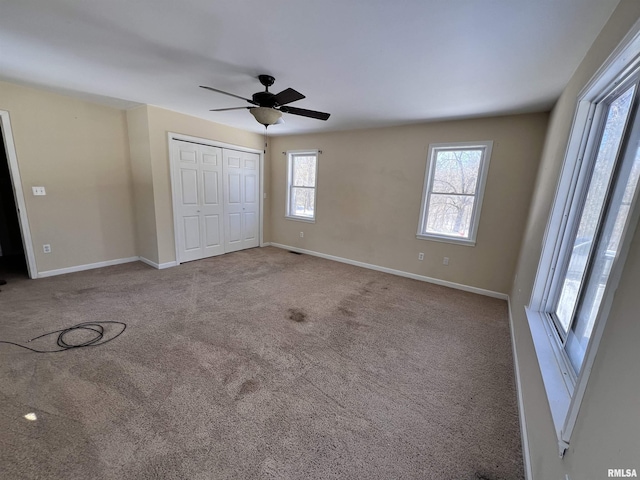 unfurnished bedroom featuring a ceiling fan, a closet, carpet flooring, and baseboards