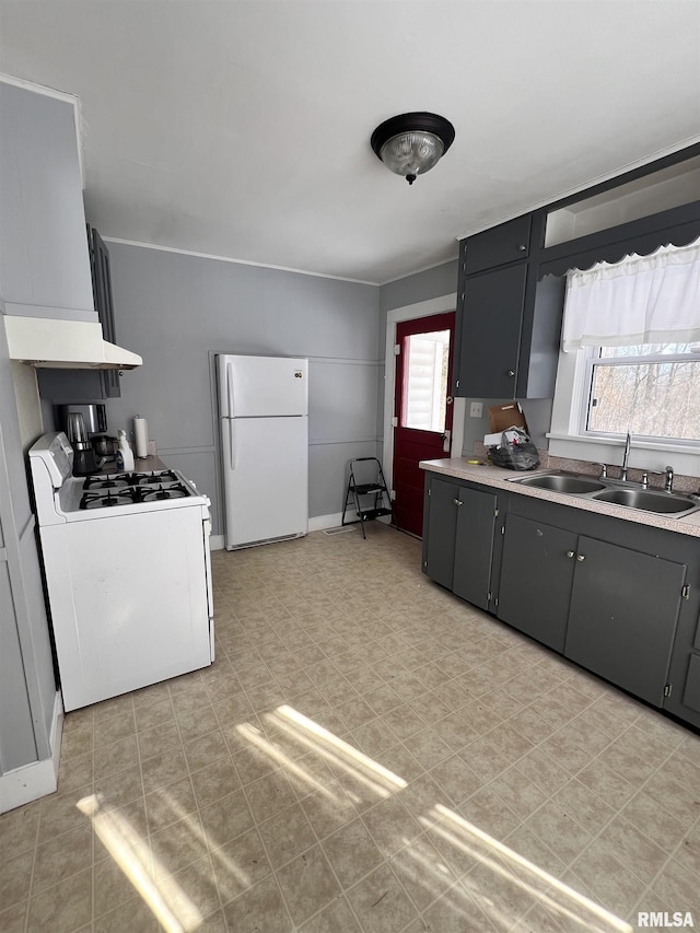 kitchen with white appliances, gray cabinets, light countertops, and a sink