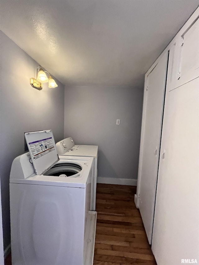 laundry area featuring laundry area, baseboards, dark wood-type flooring, and washing machine and clothes dryer