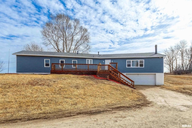 ranch-style home featuring a wooden deck, an attached garage, driveway, a front lawn, and stairs