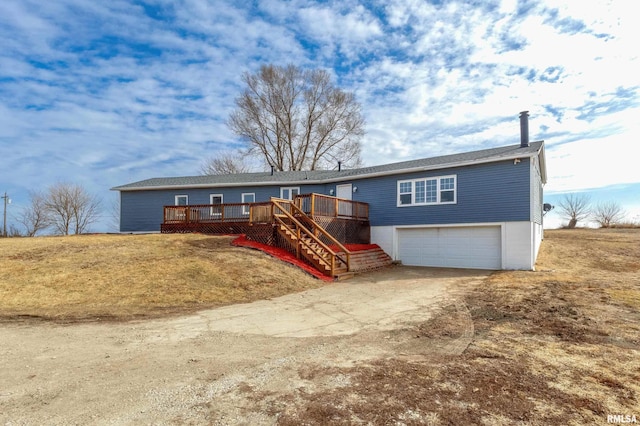 ranch-style house with driveway, stairway, an attached garage, a wooden deck, and a front lawn