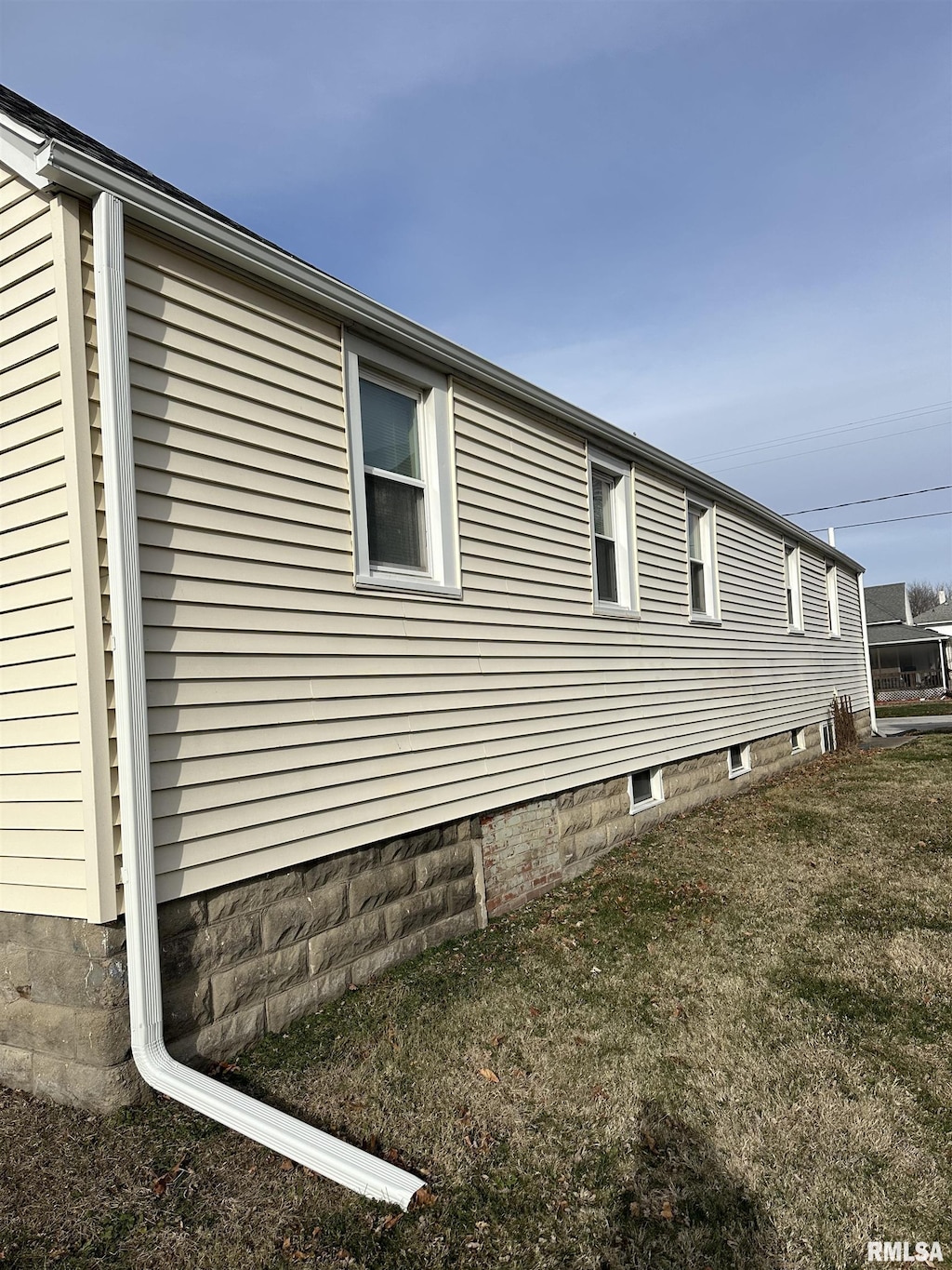 view of side of home with a yard