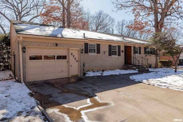 single story home featuring a garage, concrete driveway, and brick siding