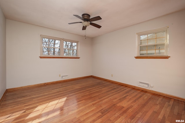 spare room with a ceiling fan, baseboards, visible vents, and light wood finished floors