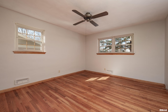 empty room with light wood-type flooring, a healthy amount of sunlight, and baseboards