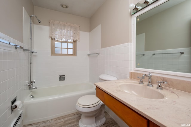 bathroom with wainscoting, toilet, vanity, shower / washtub combination, and tile walls